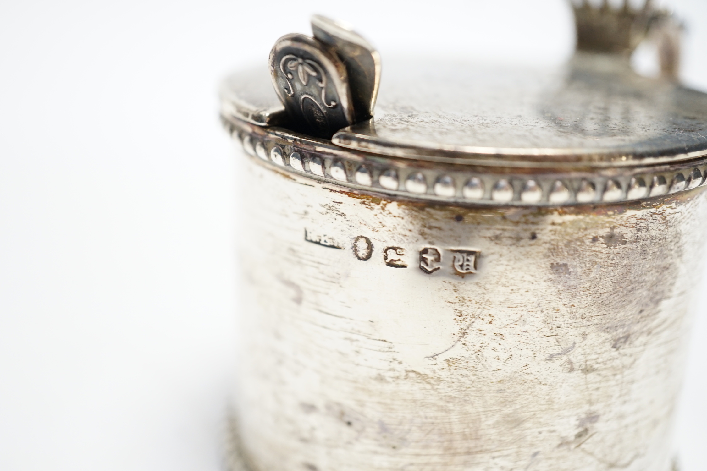 An early Victorian silver drum mustard, maker's mark rubbed, Birmingham, 1843, height 75mm, with two associated spoons, one silver.